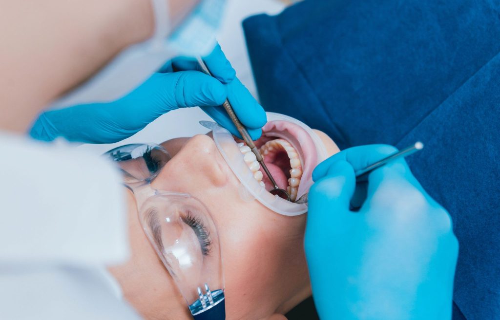 Dental professional performing sedation dentistry on a patient, highlighting a relaxed dental experience with tools for examination and treatment.