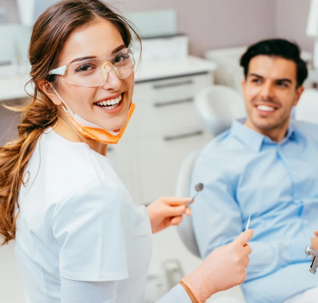 Dentist smiling at patient during consultation in a modern dental office, emphasizing care and confidence in dental implant procedures.